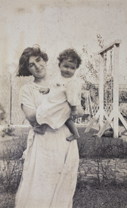 Mrs Koskey holding up her baby in the garden, 35 Tongshan Road, Hongkou, Shanghai