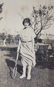 Mademoiselle Morna, with a tennis racquet, standing in the garden, 35 Tongshan Road, Hongkou, Shanghai