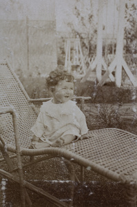 Koskey baby sitting up and smilling on a garden lounger, 35 Tongshan Road, Hongkou, Shanghai