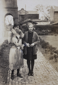 Maggie Hutchinson wearing a drop waist silk dress and fox fur stole with neighbour, Nora, in the garden, 35 Tongshan Road, Hongkou, Shanghai