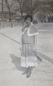 Maggie Hutchinson wearing a drop waist dress with lace trim, standing outside 35 Tongshan Road, Hongkou, Shanghai