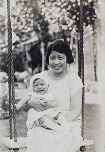 Georgina Kirby sitting on the garden swing holding her baby daughter, 35 Tongshan Road, Hongkou, Shanghai 