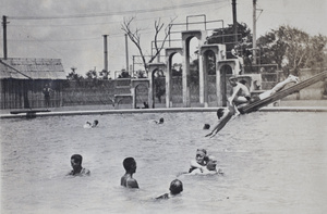 Teddie sitting on top of Bill Hutchinson diving from a slide into the Open Air Pool, Hongkou, Shanghai, 1924
