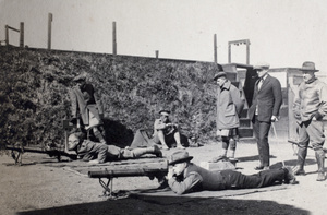 Members from various units of the Shanghai Volunteer Corps on a light artillery training exercise near an embankment, Shanghai