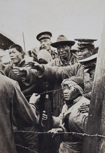 Civilians and soldiers behind barbed wire at the Avenue Haig internment camp, Shanghai