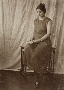 Sarah Hutchinson wearing a dress decorated with hand-sewn beading and holding a fan, Hongkou, Shanghai