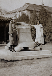 Sarah Hutchinson and Sonia Gotfried standing either side of a large bell, Jessfield Park (Zhongshan Park 上海中山公园), Shanghai