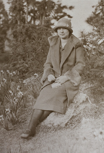 Sarah Hutchinson sitting beside narcissus flowers, Jessfield Park, Shanghai, April 1925