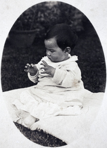 Bea Hutchinson sitting up on a baby quilt in the garden, 35 Tongshan Road, Hongkou, Shanghai