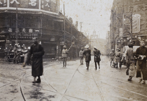 People crossing the corner of Nanjing and Hubei Roads, where members of Shanghai Fire Brigade, Sikh Municipal Shanghai Police and Shanghai Volunteers Corps are out in force, Shanghai, 1925