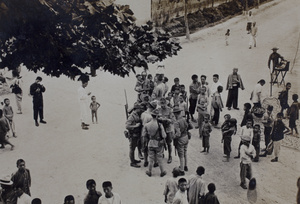 People gathering around six American Company Shanghai Volunteer Corps members near the Huasing Road tram sheds, Shanghai, 1925