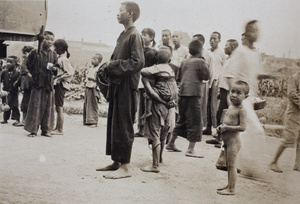 Children and young people gathering to collect rice from a truck near the Huasing Road tram sheds, Shanghai, 1925