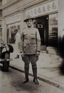 Mr Gerschwind, American Company Shanghai Volunteer Corps member, standing in the street outside a furniture store, Shanghai, 1925