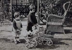 Gladys and Bea Hutchinson standing with play prams near the garden summer house, 35 Tongshan Road, Hongkou, Shanghai