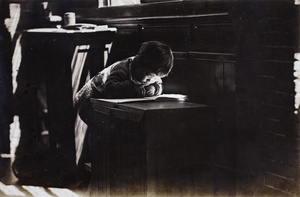 Shadows and light falling on Gladys Hutchinson looking at a book, 35 Tongshan Road, Hongkou, Shanghai