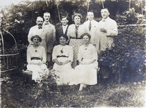 Group of unidentified women and men in a garden