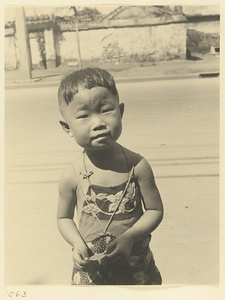 Child wearing apron with appliqué work