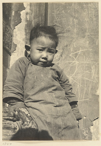 Boy next to wall with grafitti