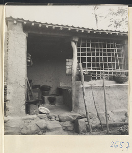 Detail of a house showing entrance, latticed window, and household goods in the Lost Tribe country
