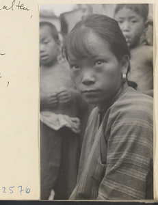 Woman wearing earrings and a striped shirt in Tio-liu-po Village [sic]