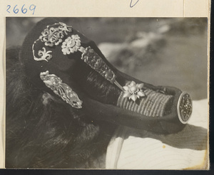 Woman wearing a silver hair ornament with blue inlay work in the Lost Tribe country