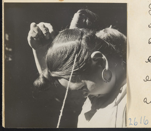 Woman doing her hair in the traditional teapot style in the Lost Tribe country