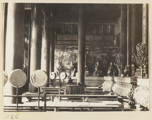 Interior view of Da cheng ge at Da Fo si showing drums, Luohans seated in front of a mural, and altars with trees