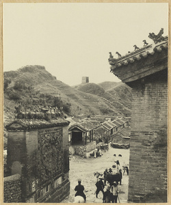 Soldier on horseback, villagers, and building details showing roof ornaments and glazed-tile relief work in the village of Gupei