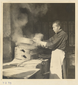 Cook opening a bamboo steamer basket in a restaurant in Baoding