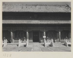 Detail of a building with a double-eaved roof showing entrance with incense burners in the Forbidden City