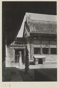 Building with roof ornaments and courtyard with incense burners mounted on stone pedestals in the Forbidden City