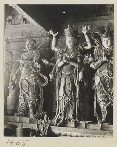 Statue of a multi-armed Bodhisattva flanked by two shrine figures holding an ax and a sceptre at Da Fo si