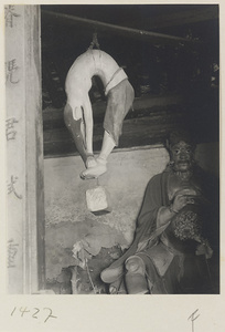 Interior view showing inscription, male figure hanging by his waist, and shrine figure at Dong yue miao