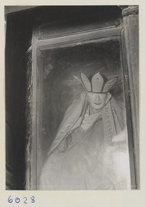 Statue of a shrine figure in a glass case at Tie ta