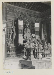 Interior of temple building at Yong he gong showing altar with statues of a Bodhisattva and attendants