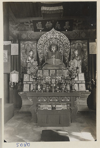 Interior of temple building at Yong he gong showing altar with statues of Buddha and attendants