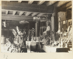 Interior view showing altars with draped Buddha figures, ritual objects, and figurines at Tan zhe si