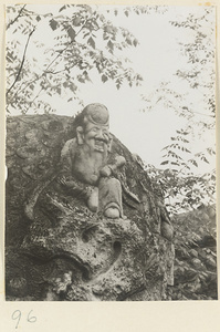 Detail of carved stone ding showing a relief figure at Gang Tie miao