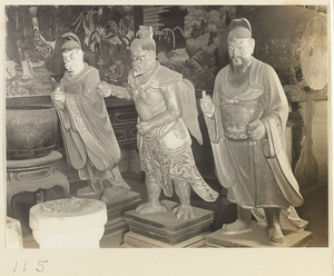 Shrine interior at Hei long tan showing three shrine figures (one with bird's beak, wings, and talons), musical instruments, and details of two murals