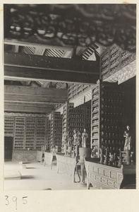 Temple interior showing niches with temple statues and ritual objects and walls with Bodhisattva reliefs at Wan shou si