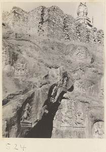 Buddha reliefs cut into hillside and stupa-style pagoda at top of Yuquan Hill