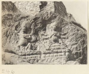 Two Buddhist relief figures, one with headdress and necklace of skulls, carved into the hillside at Yuquan Hill