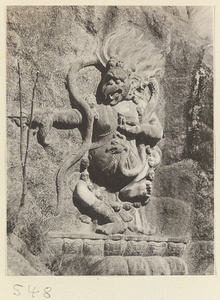 Buddhist relief figure with animal head and scull necklace carved into the hillside at Yuquan Hill