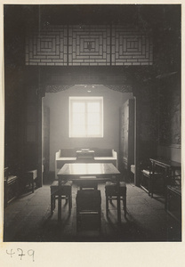 Interior of a temple building showing a room with tables, chairs, cabinets, and latticework at Fa yuan si
