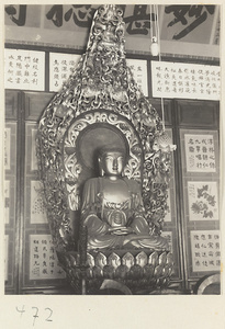 Temple interior showing statue of Buddha on a lotus throne with scrolls and scroll paintings at Fa yuan si
