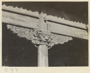 Facade detail of double-eaved temple building showing column with animal-headed capital at Huang si