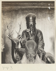Daoist statue holding a ru yi sceptre and sitting on a deer