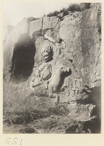 Relief figure of an equestrian wearing a headdress of skulls carved into the hillside at Yuquan Hill