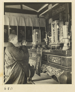 Buddhist nun kneeling at altar