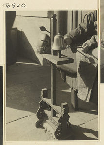 Buddhist nun striking a mu yu and a metal bell